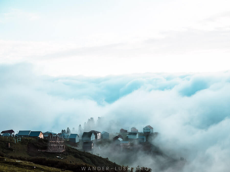 Cloud cover tiny houses on a mountain in Georgia.