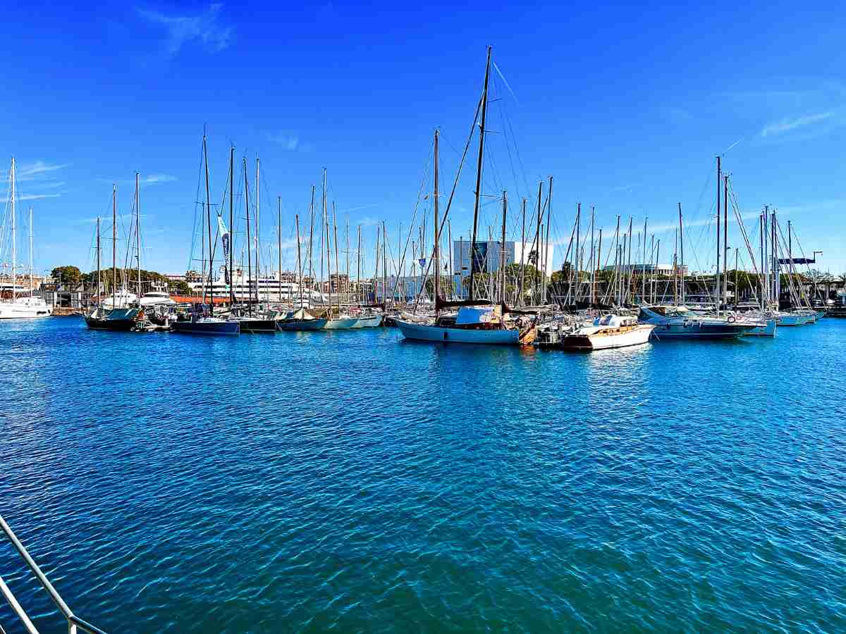 beautiful calm view of the harbour at Port Vell Barcelona. Boats docked, clear blue skies and blue waters on a winter's day in Barcelona