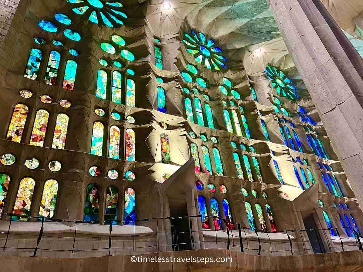 inside la sagrada familia light streaming through colouful glass in blue green 