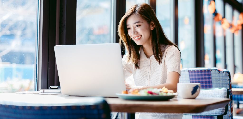 A woman working laptop at a cafe.