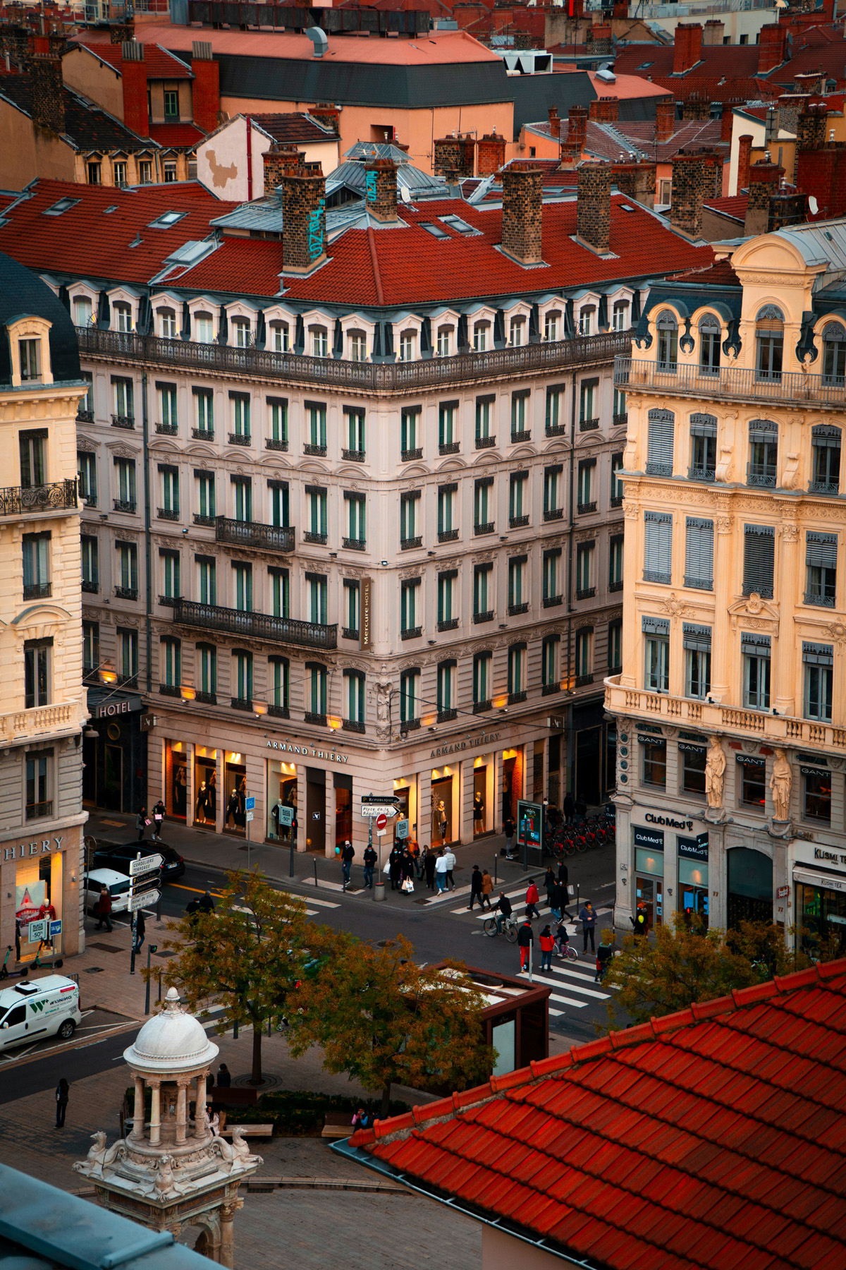 Tall classical buildings in Lyon, France, glow golden at sunset.