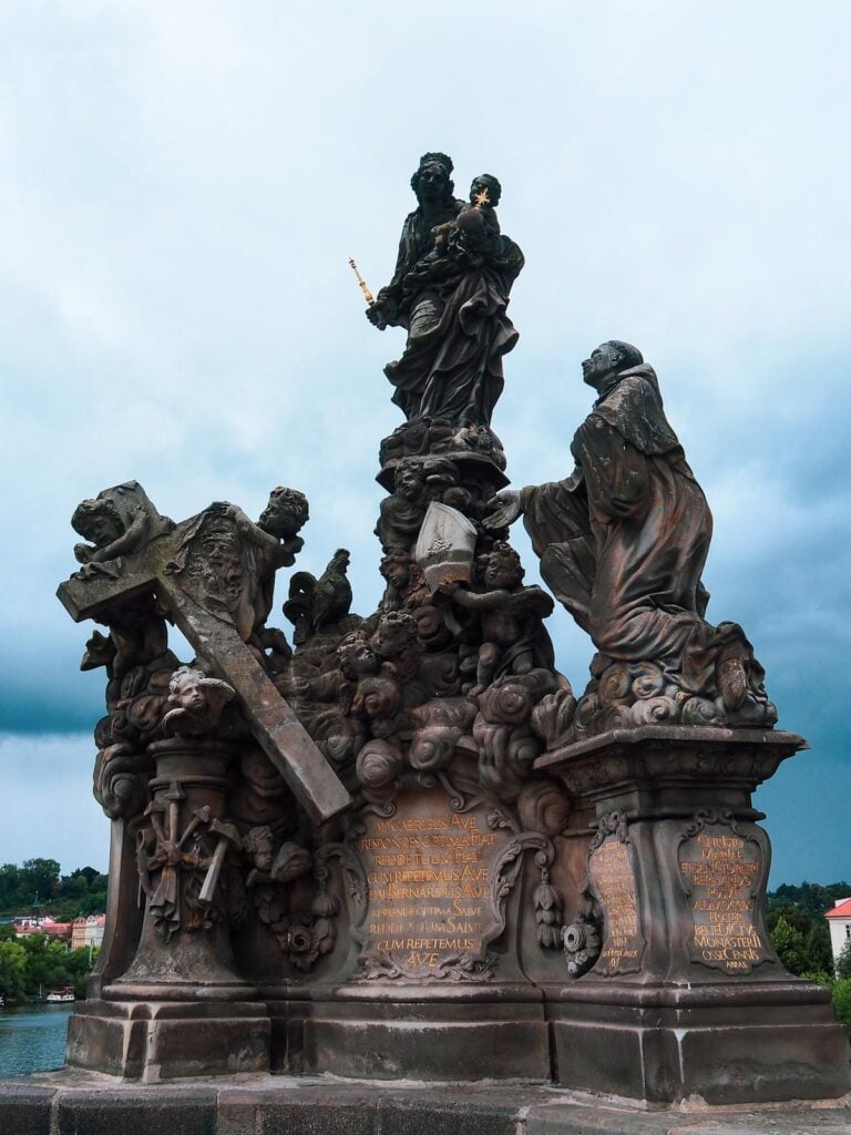 Gothic statue on Charles Bridge, Prague, against stormy sky