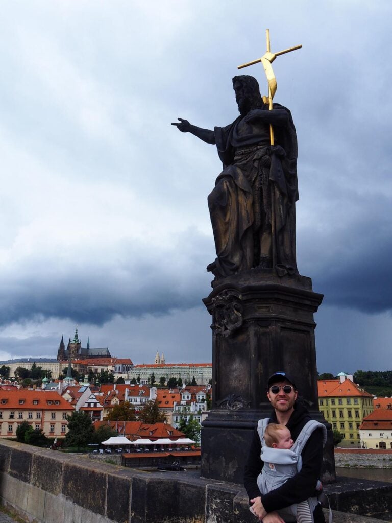 Father and baby on Charles Bridge with historic statue, Prague Castle in the background (source: [MB Bryant Images](https://mbbryantimages.com/2022/10/27/image-alt-text-how-photographers-should-be-using-it-correctly/))