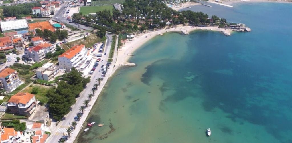 An aerial view of a beach and a building near it. 