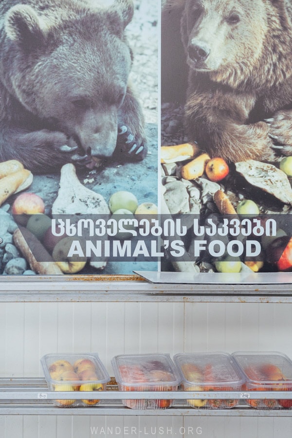 A poster and racks of vegetables for sale at the Zoological Center in Georgia.