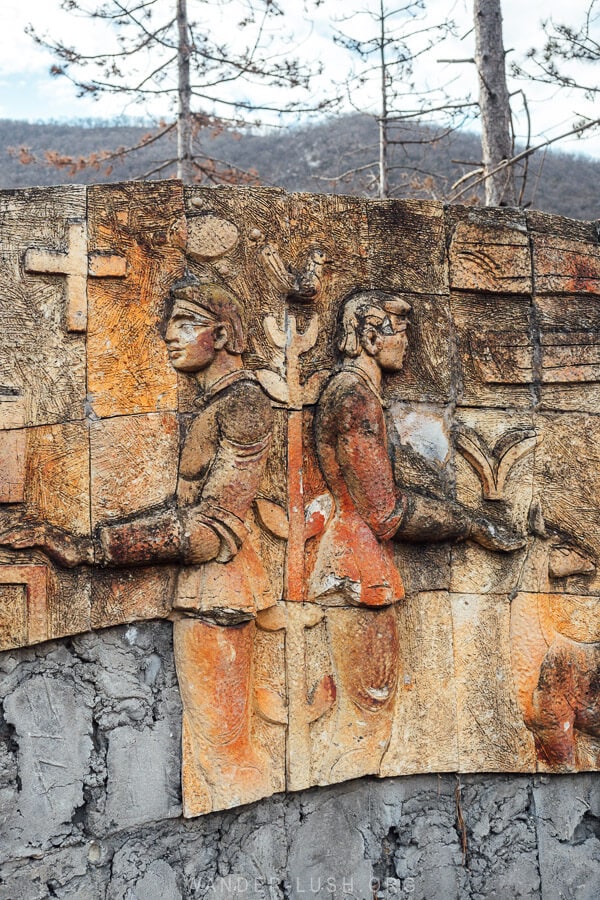 A Soviet-style bas relief sculpture depicting two people holding flora.