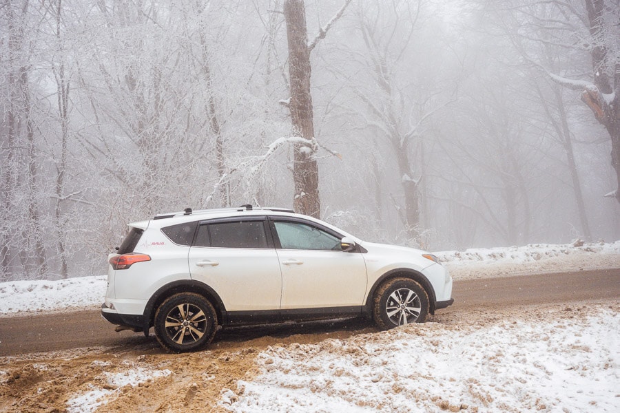 A white car parked on the side of the road inside Forest Sabaduri in Georgia.