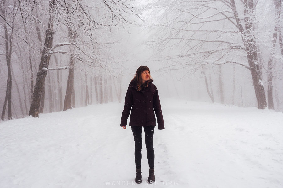 Emily standing in the snow in Sabaduri Forest dressed in winter clothing.