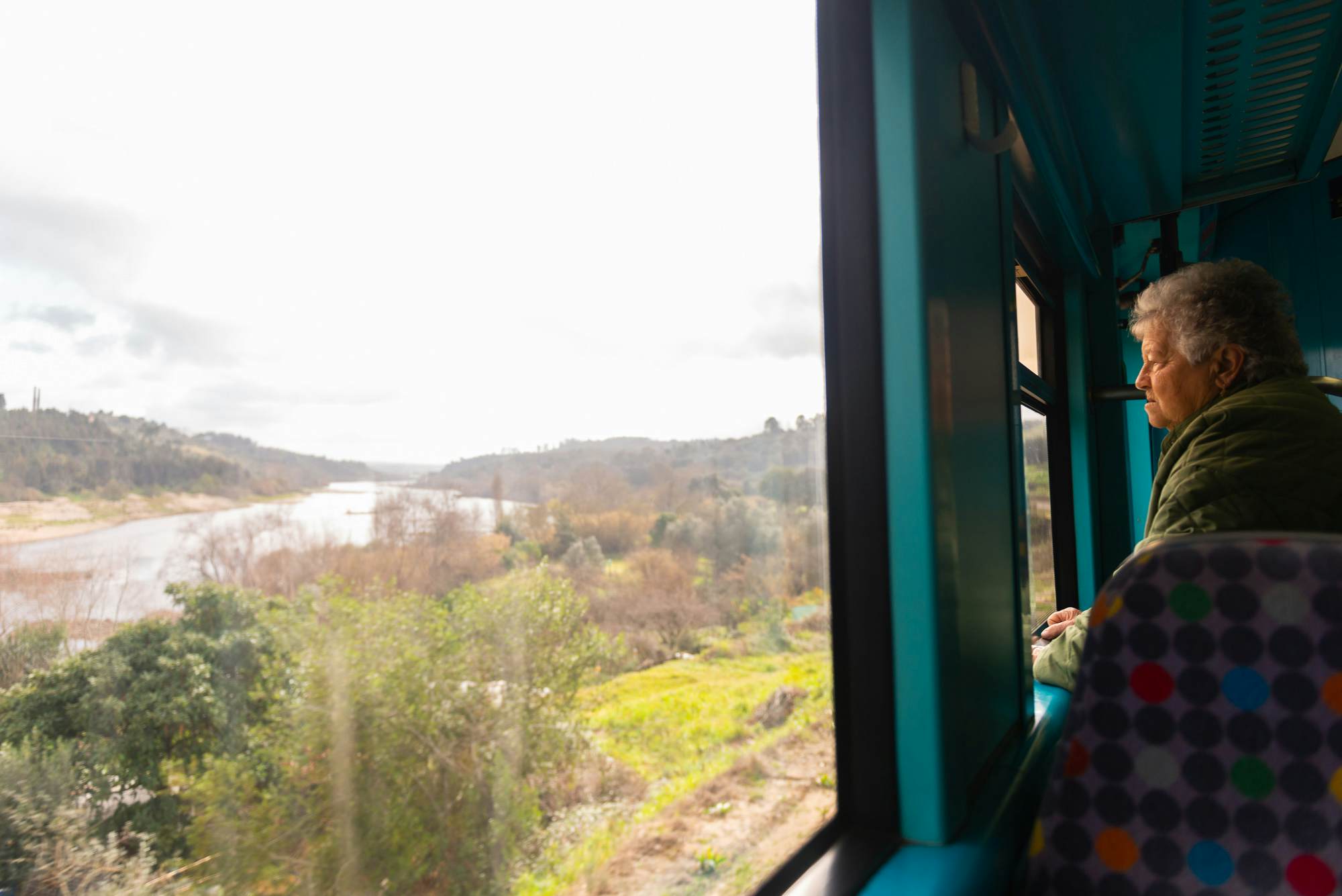 A passenger looks from a train window out at the Tagus River, Portugal