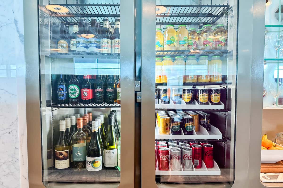 Fridge full of refrigerated drinks and bottles of wine