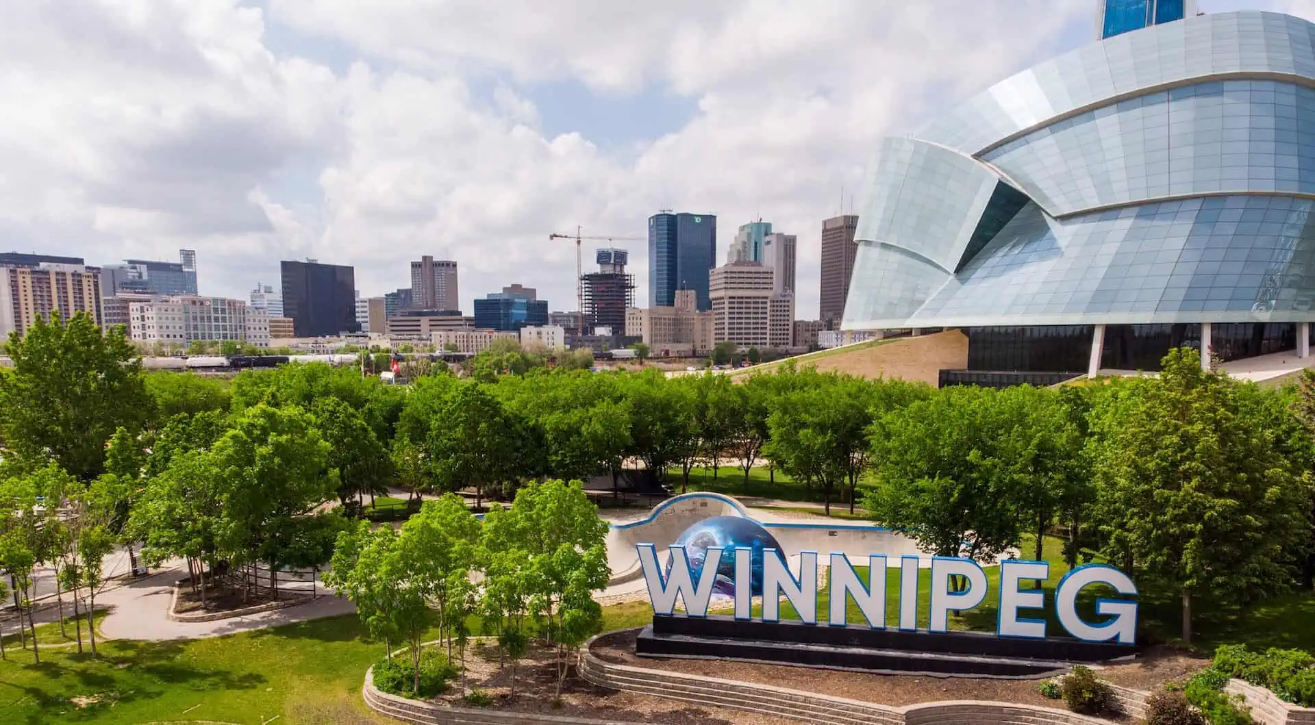 Winnipeg, Manitoba skyline with buildings, trees and the Winnipeg sign; visited on a Canada road trip