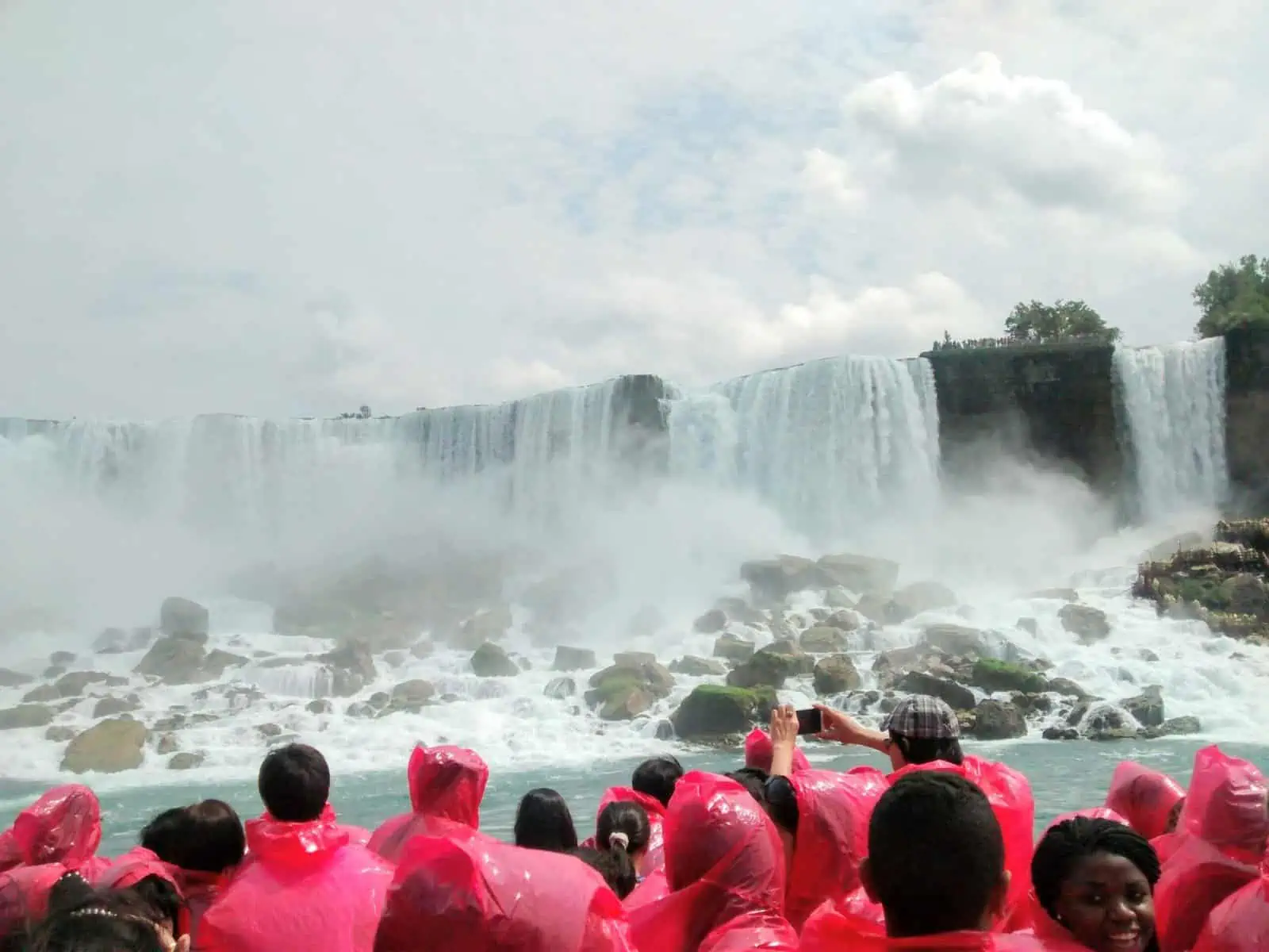 Guests wearing red rain slickers on a cruise down to Niagara Falls, Ontario, Canada