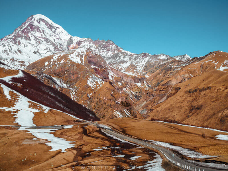 Orange-red mountains with a highway running through the middle.