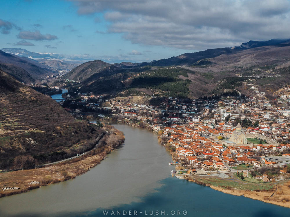 A red-roofed town on the side of a river.