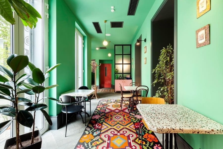 An upbeat hotel hallway with bright colours and indoor plants.