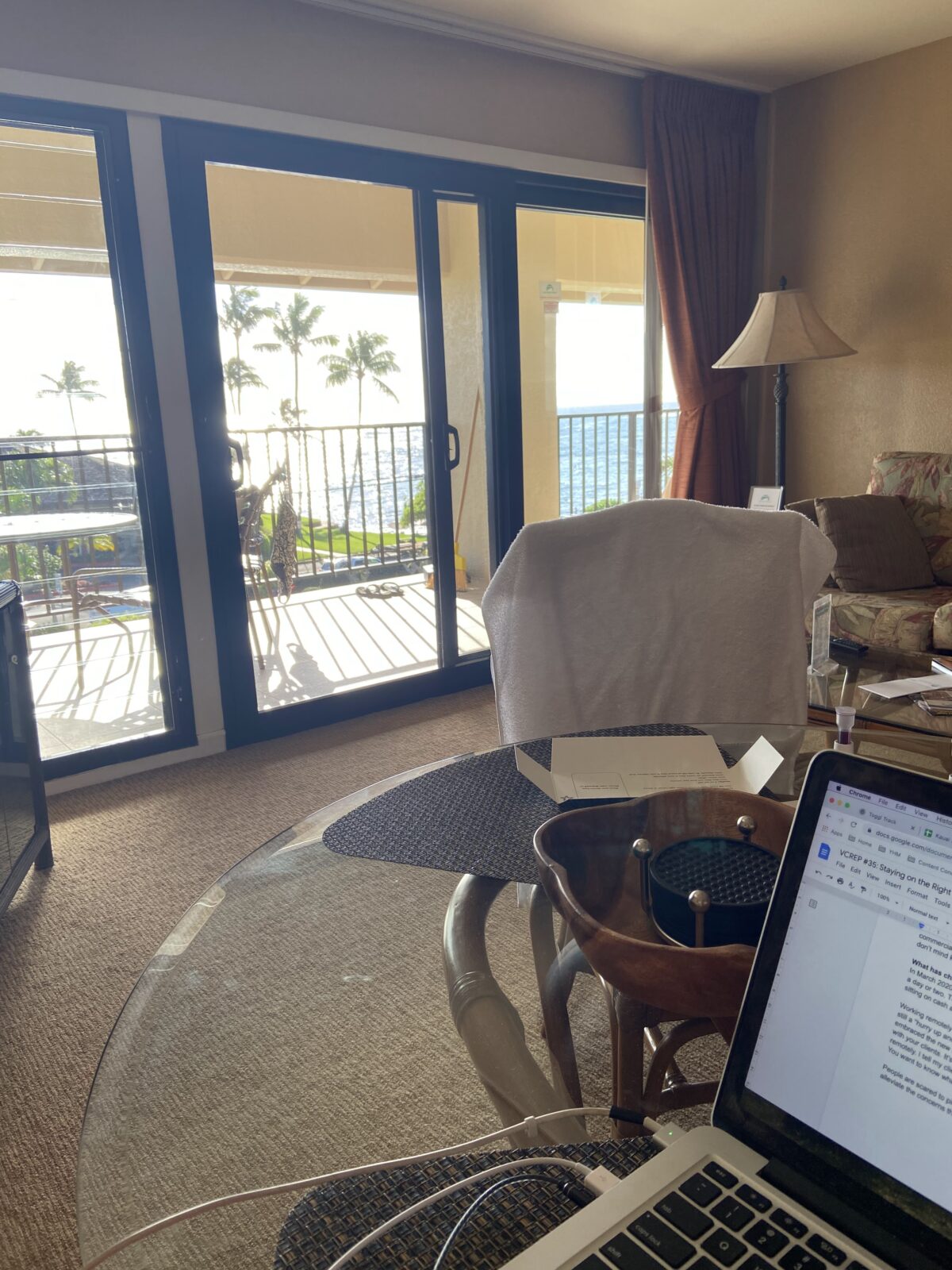 Laptop on a desk with a view of the balcony behind it at a resort in Hawaii