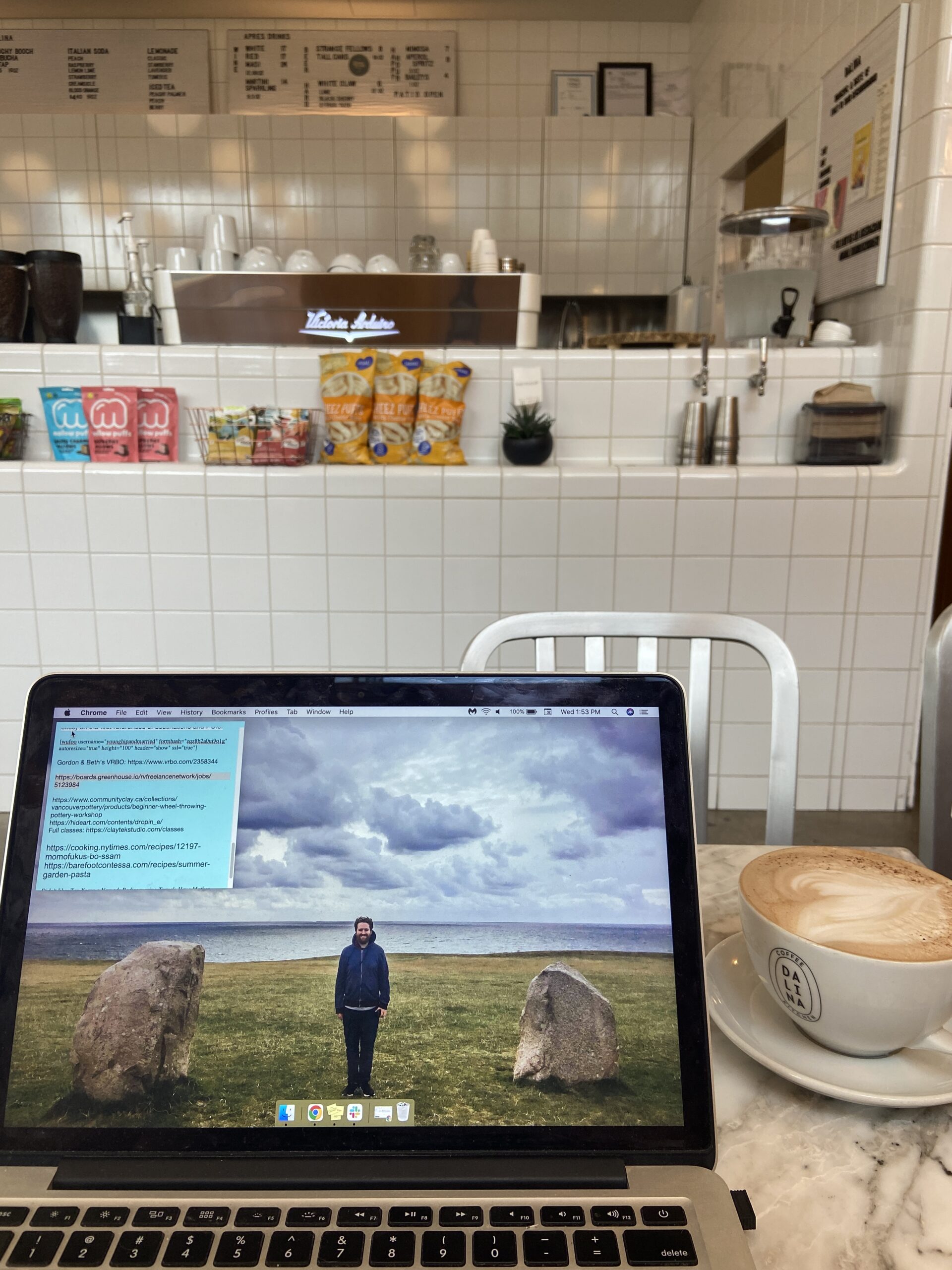 Working from a coffee shop with my laptop open and mug of coffee next to me; freelancer tips for beginners