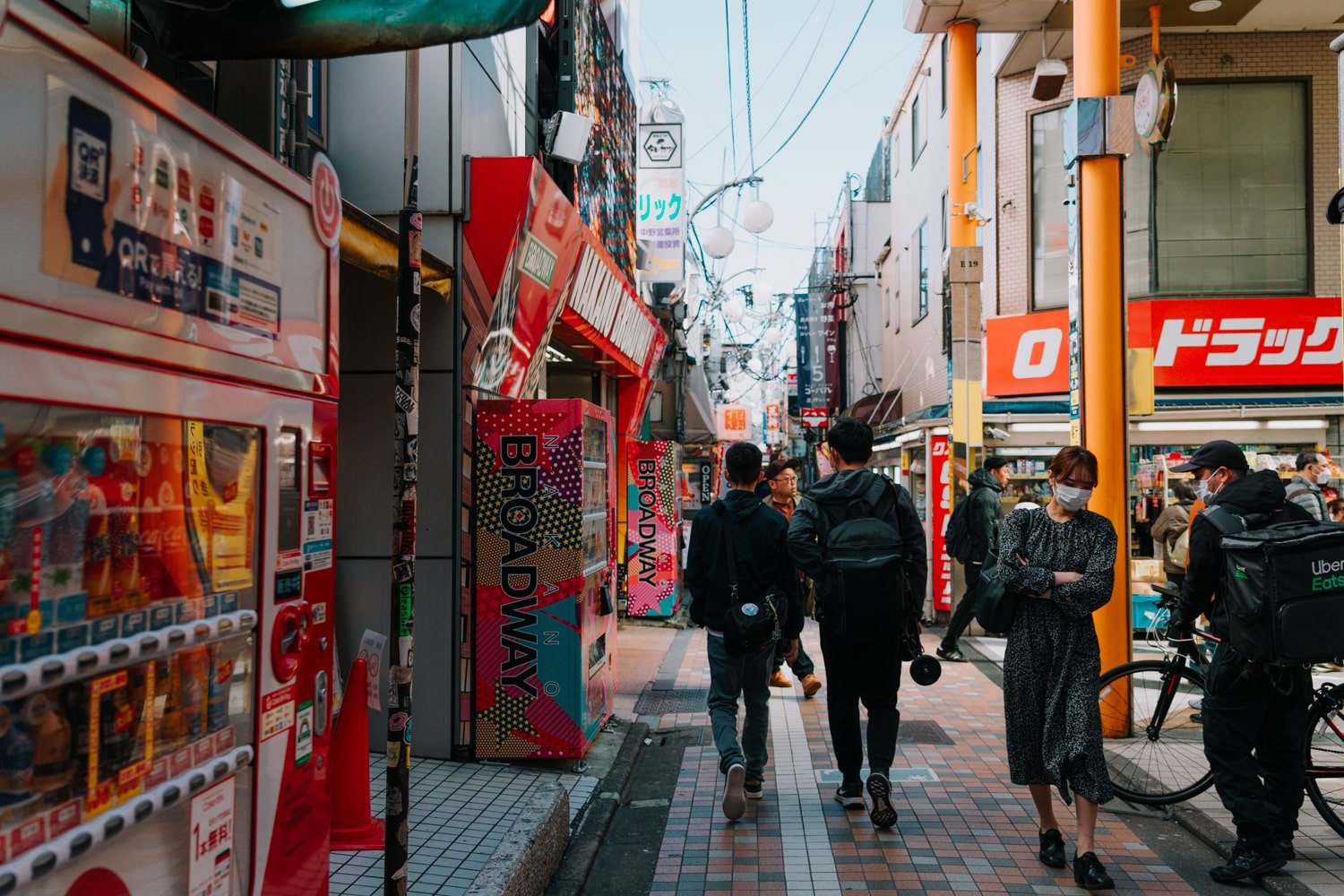 Locals walking down shop-lined street in Nakano, Tokyo, Japan.