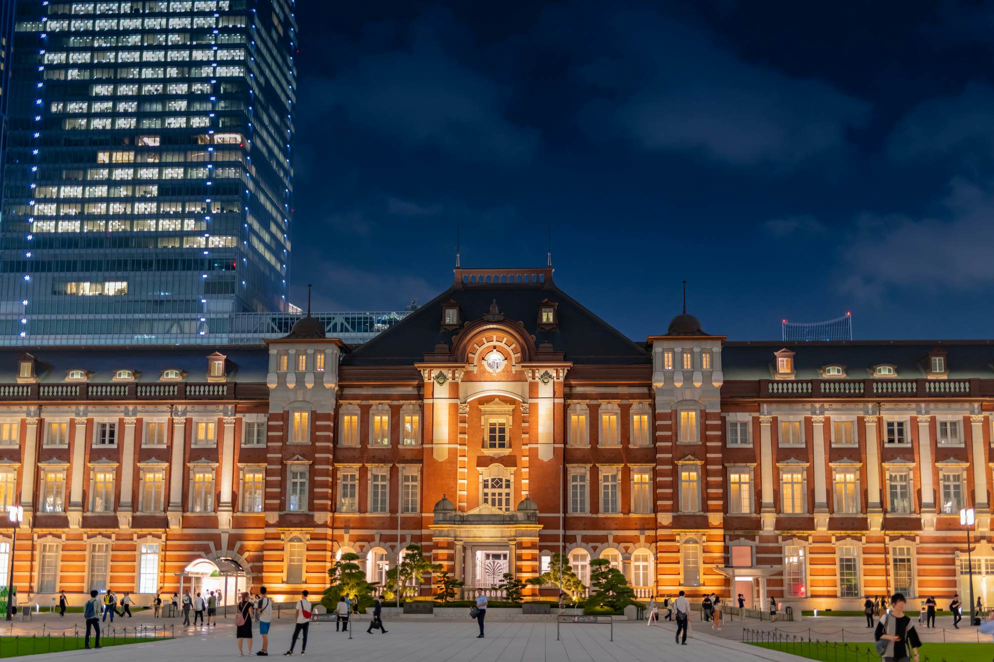 Night shot of the exterior of a large red-brick station building