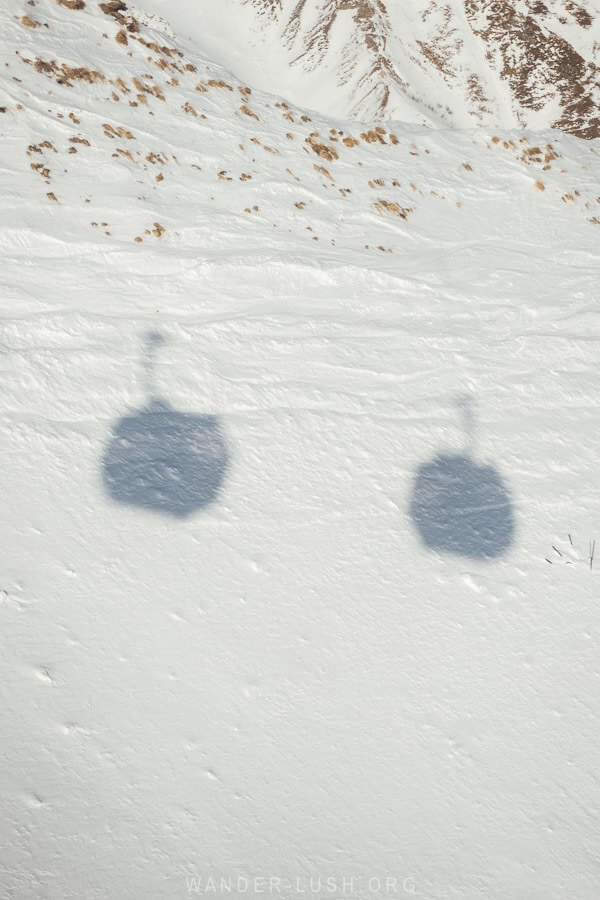 The shadows of two box-shaped gondolas on the Gudauri Kobi cable car in Georgia.