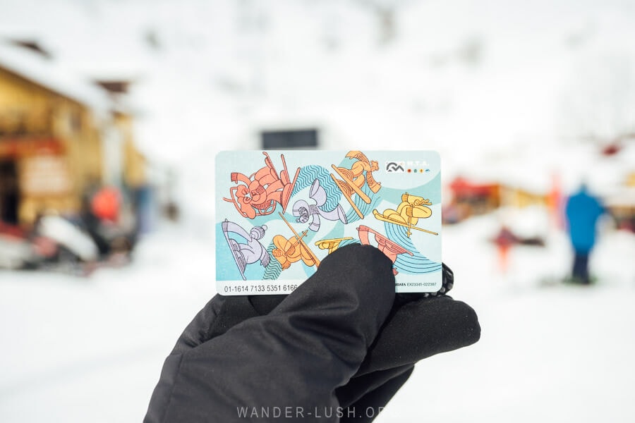 A woman holds a Gudauri ski pass in her hand.