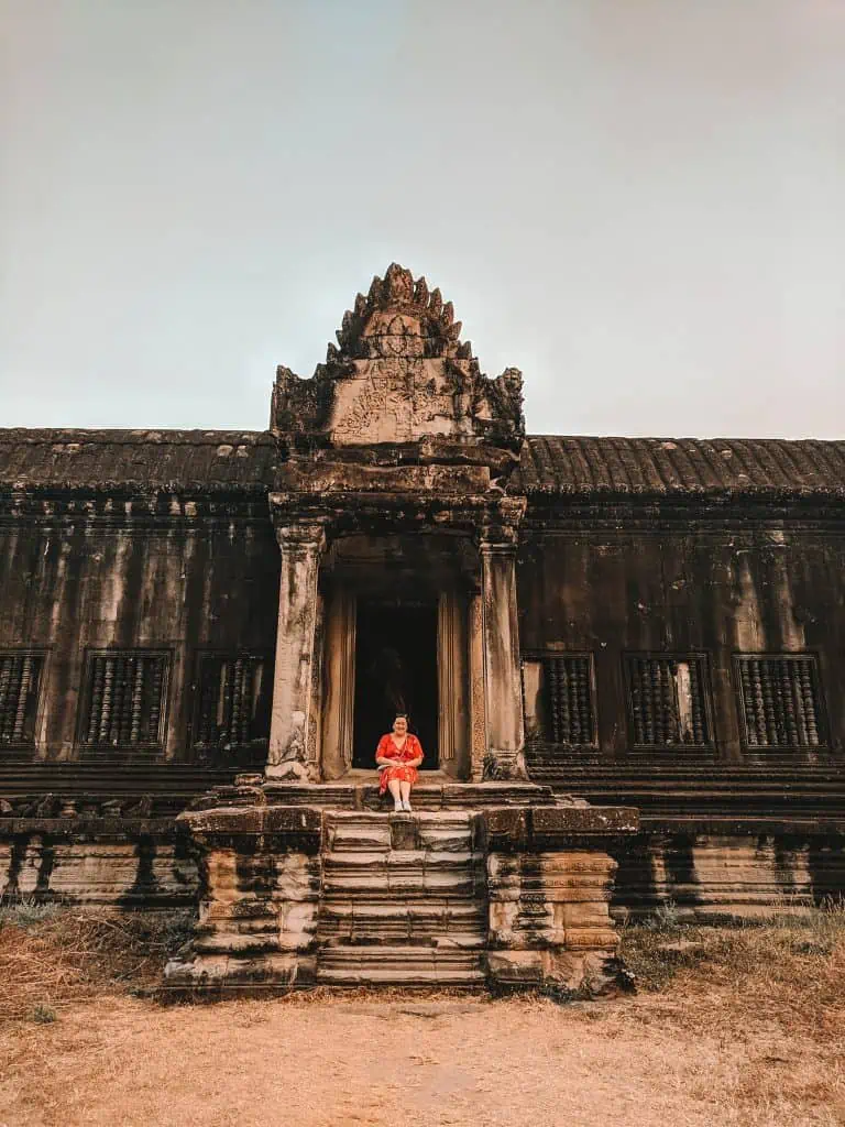 Riana sitting on the stairs of a temple at Angkor Wat 