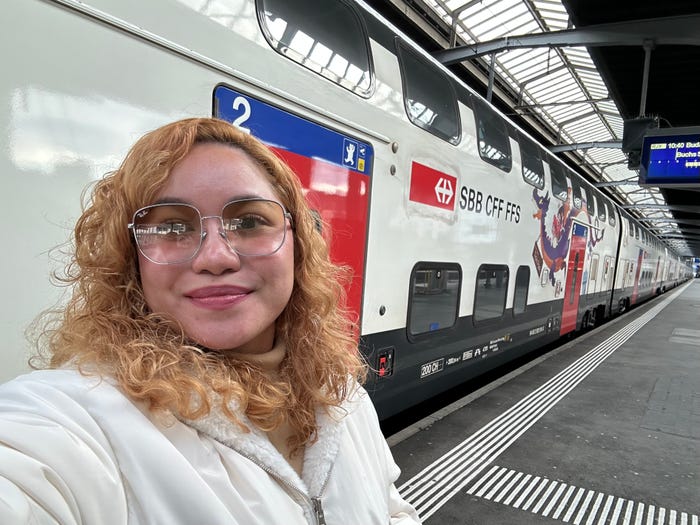 woman taking selfie front of a train in europe.