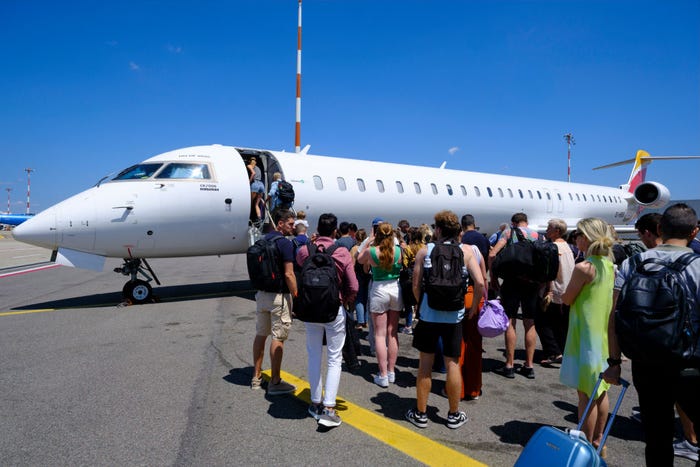 Line of people waiting to board a plane on the tarmac