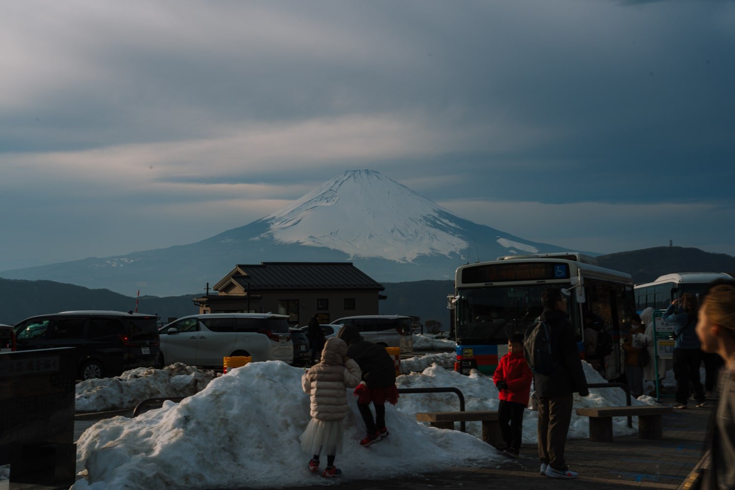 View of Mt Fuji with snow and crowds at Owakudani station.