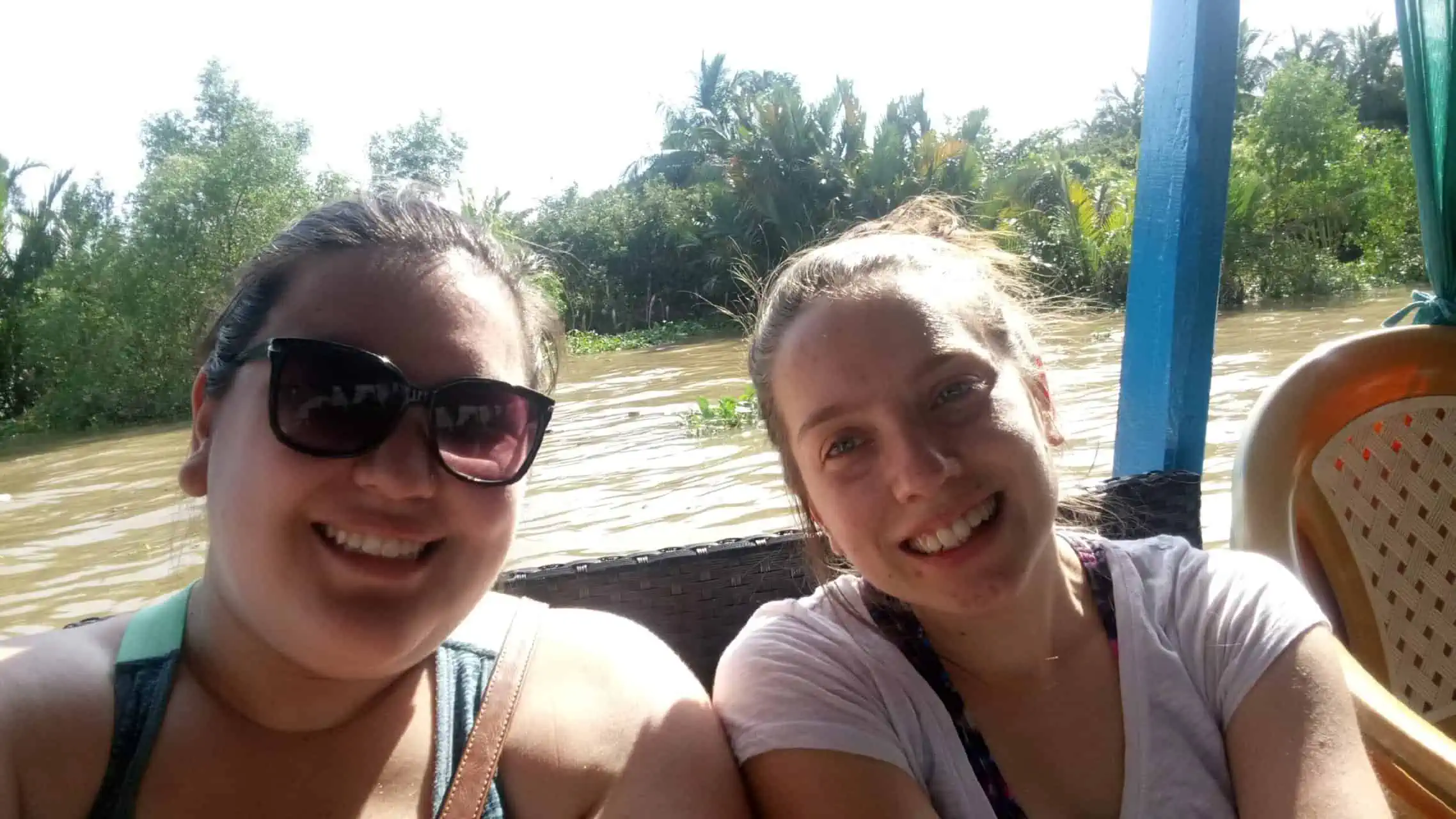 Riana and Emilie smiling for a selfie on a boat during a Mekong Delta tour in Vietnam