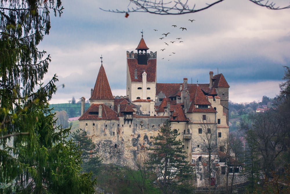 Dracula's Castle in Romania with an eerie sky and bats