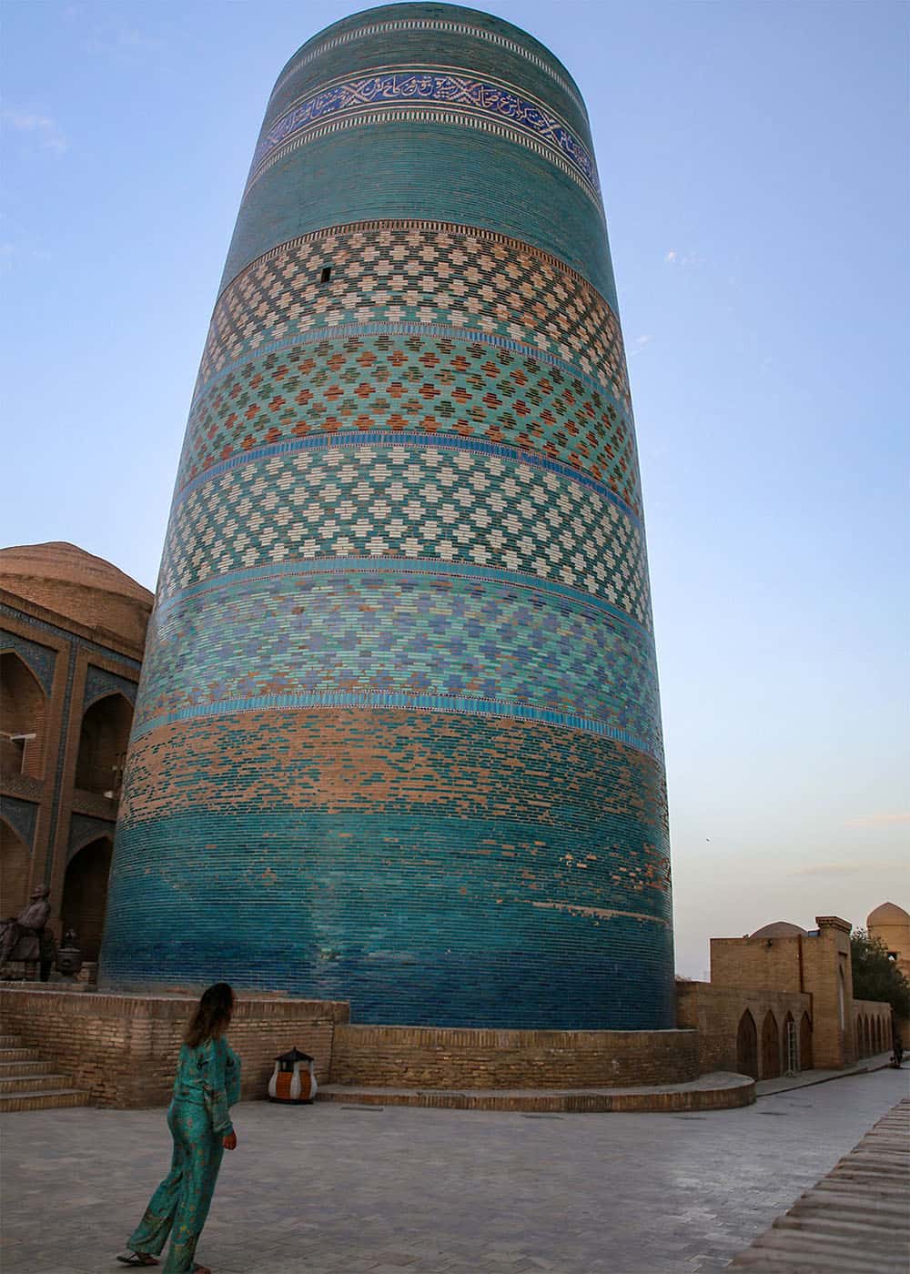 Saskia in Khiva Uzbekistan in front of a large blue monument