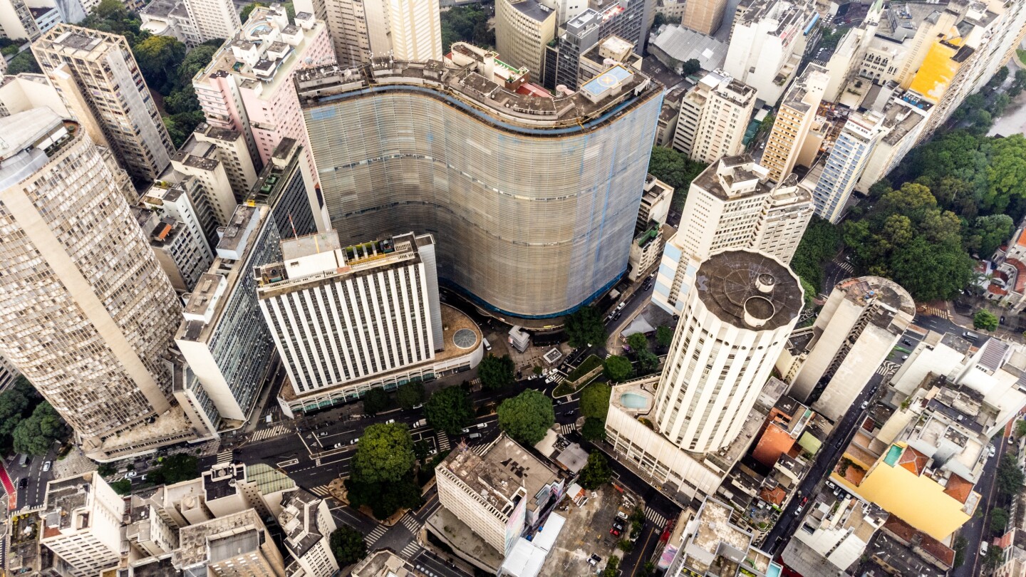 Aerial view of tall buildings, including wavy Copan building and a circular white tower, in the city of São Paulo 