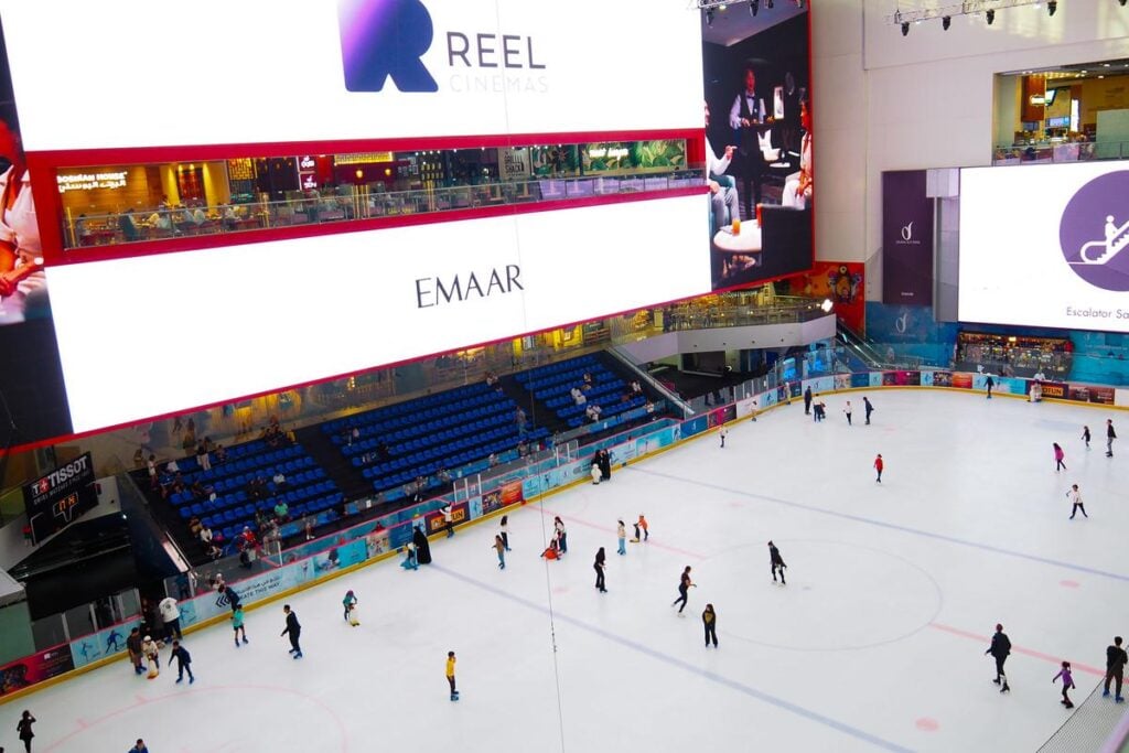 Indoor Ice Skating at Dubai Mall's State-of-the-Art Rink - Skaters gliding on ice, Reel Cinemas signage, luxury mall ambiance