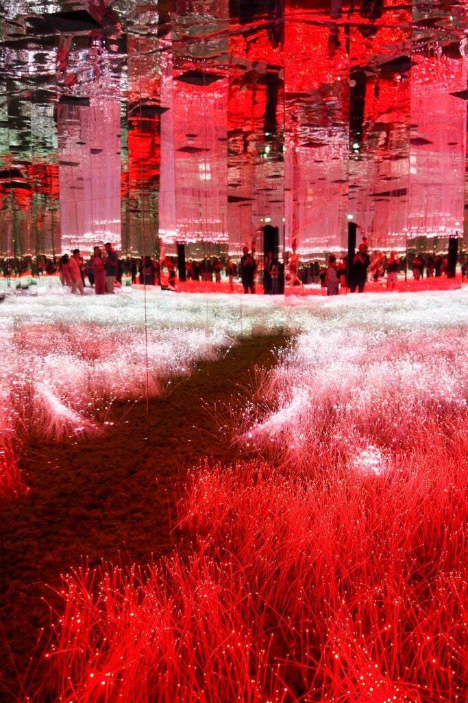 AYA Universe Dubai art installation with mirrored columns and red fiber optic lights.