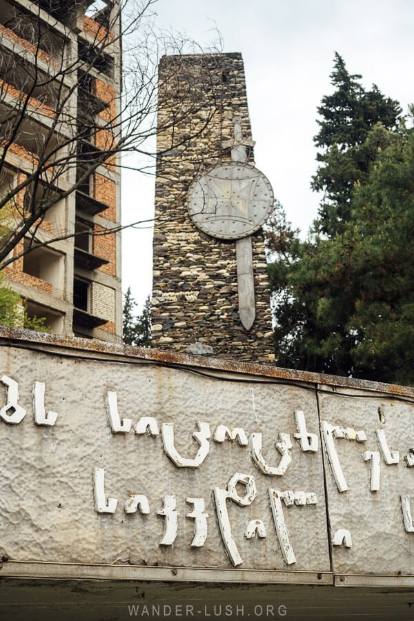 A war memorial in Gurjaani featuring Georgian text and a stone monument with a metal sword and shield.
