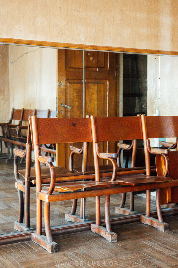 Wooden seats in front of a mirrored wall inside a dance studio in the Vazisubani Palace of Culture.