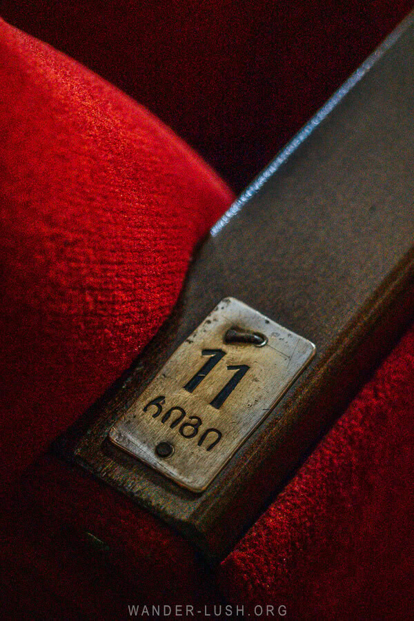 A metal seat number on an arm rest inside the Vazisubani Palace of Culture.