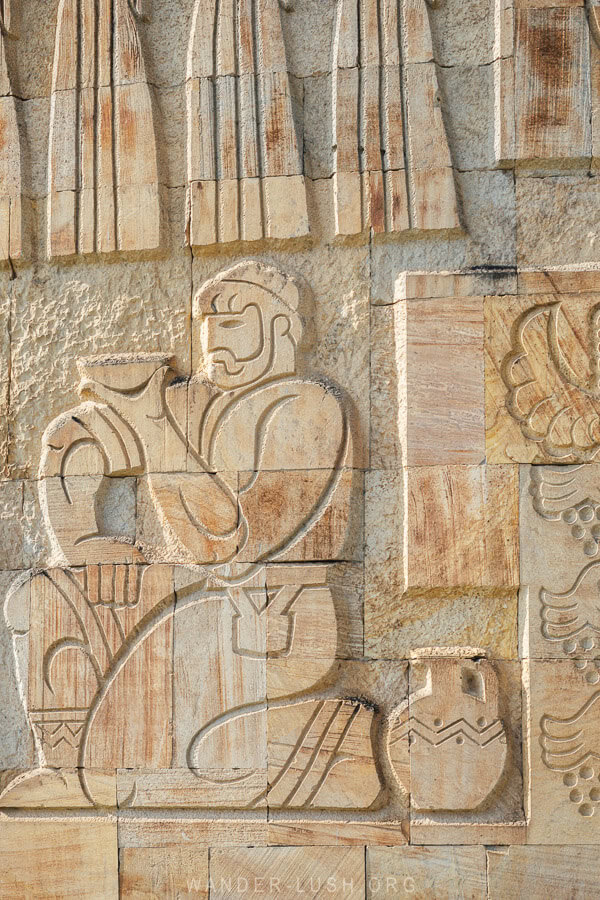 Details of a stone relief panel at the memorial in Gurjaani showing a man drinking wine from a clay cup.