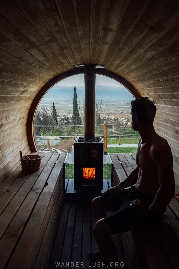 A man sits inside a barrel sauna at a boutique hotel in Kakheti.