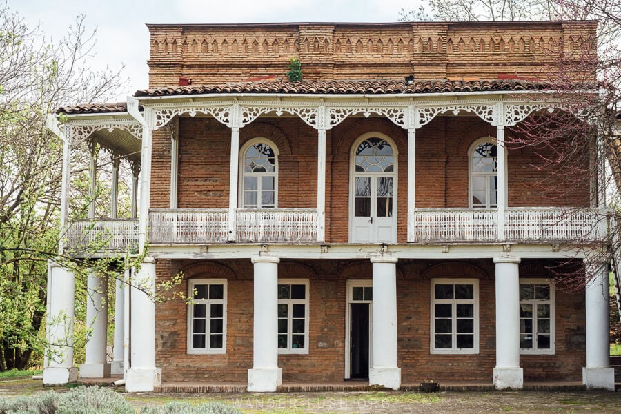 A historic building in Kakheti with a white wrap-around veranda, the Nato Vachnadze House Museum.