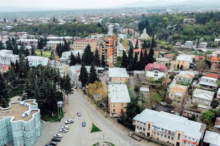 Aerial view of the city of Gurjaani, Georgia, with low-rise apartment blocks and a modern Public Service Hall building.