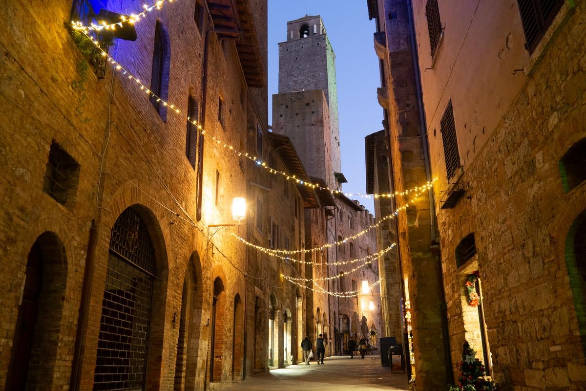 Twilight over cobblestoned San Gimignano, medieval towers rising against the Italian sky