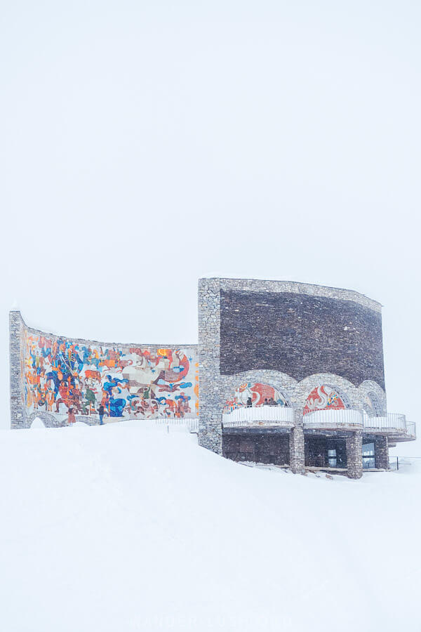 The Russian-Georgian Friendship monument, a large monument with a mosaic, in winter.