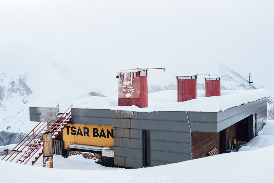 Tsar Bani, a sauna in Gudauri with three smokestacks emerging from the snow.