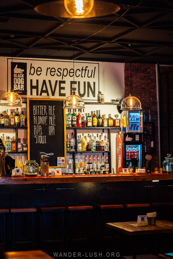 Black Dog Bar, a cool bar in Gudauri with bottles of liquor on display and a blackboard sign.