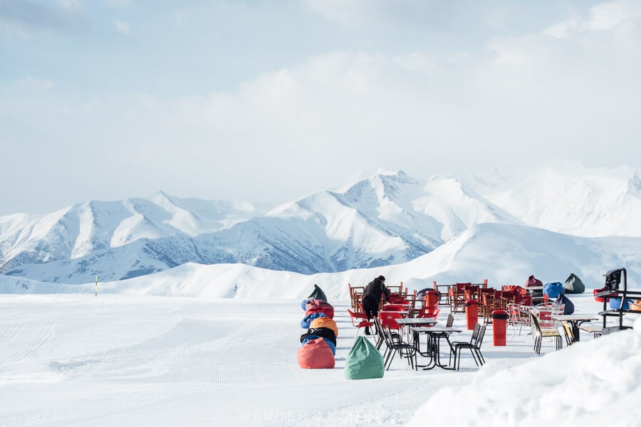 An outdoor bar with tables and bean bags set up on the ski slopes in Gudauri.