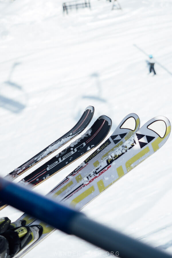 Two pairs of skis hovering over the ski fields in Gudauri, as seen from a chairlift.