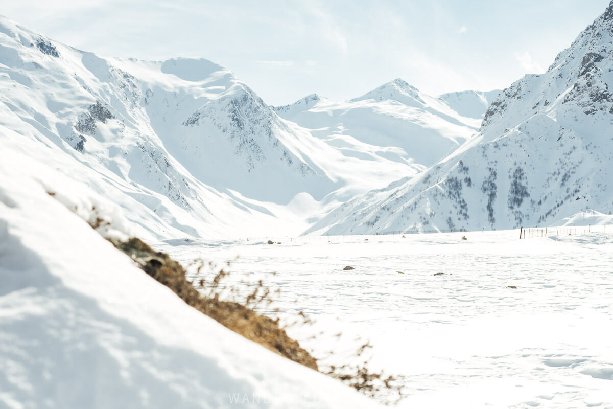 A beautiful valley near Gudauri in Georgia, with the ground covered in fresh powder and the surrounding mountains covered in snow.