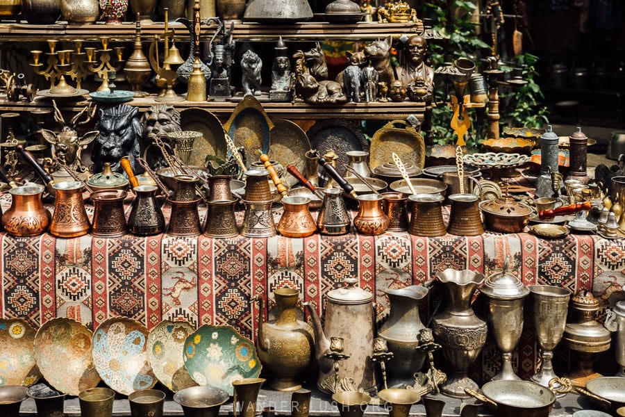 Antique samovars and coffee pots displayed on a carpet at a shop inside the Baku Old City walls.